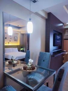 a living room with a glass table and blue chairs at TWO PALMTREE VILLAS NEWPORT BOULEVARD NEAR NAIA 3 PASAY CITY in Manila