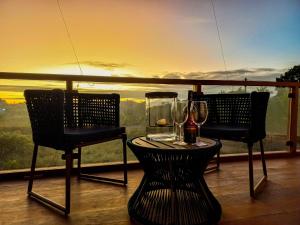 d'une table et de chaises avec des verres à vin sur le balcon. dans l'établissement Oceà Privilegi - Taipu de Fora, à Barra Grande