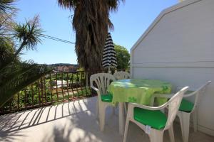 une table et des chaises assises sur une terrasse dans l'établissement Apartments and rooms with a swimming pool Cavtat, Dubrovnik - 4733, à Cavtat