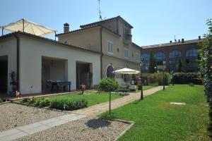 ogród z domem i parasolem w obiekcie Homelink Poggibonsi - Sogno D'oro w mieście Poggibonsi
