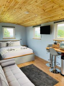 a bedroom with a bed and a desk with a computer at Red darren luxury hut in Llanveynoe