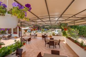a patio with tables and chairs and plants at Double Room Mali Losinj 3445h in Mali Lošinj
