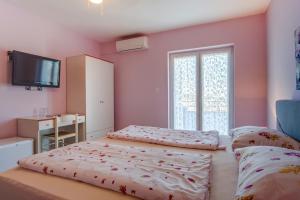 a bedroom with two beds and a flat screen tv at Double Room Mali Losinj 3445h in Mali Lošinj