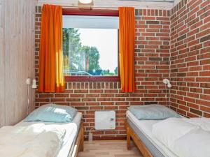 dwa łóżka w pokoju z ceglaną ścianą w obiekcie Holiday Home Strandskadevej w mieście Ørsted