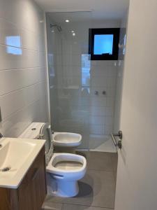 a bathroom with a toilet and a sink and a tv at departamento San Carlos in Mar del Plata