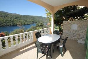 a table and chairs on a balcony with a view of a river at Apartments by the sea Duga Luka - Prtlog, Labin - 3025 in Labin