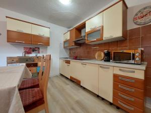 a kitchen with wooden cabinets and a counter top at Apartments by the sea Duga Luka - Prtlog, Labin - 3025 in Labin