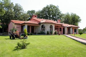 une maison avec une pelouse verte devant elle dans l'établissement Luxury villa with a swimming pool Belavici, Marcana - 3028, à Barban