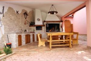 a kitchen with a wooden table and a fireplace at Luxury villa with a swimming pool Belavici, Marcana - 3028 in Barban