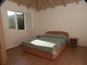ein Schlafzimmer mit einem Bett in einem Zimmer mit einem Fenster in der Unterkunft Apartments by the sea Milna, Vis - 3036 in Vis