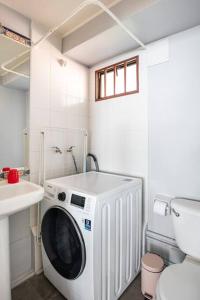 een wasmachine in een badkamer naast een toilet bij Departamento Cerro Alegre 113 in Valparaíso