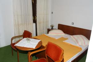 a bedroom with a bed with chairs and a table at Apartments by the sea Baska Voda, Makarska - 2724 in Baška Voda