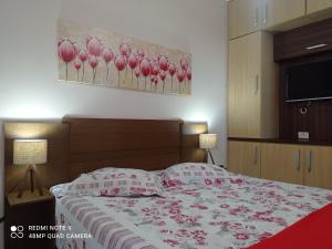 - une chambre avec un lit orné de fleurs roses dans l'établissement Mata Atlântica - Excelente custo benefício na Praia do Morro, à Guarapari