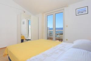 1 dormitorio con 1 cama grande con manta amarilla en Apartment Balica Rat 2753a en Tice