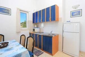 a kitchen with a table and a white refrigerator at Apartment Balica Rat 2753a in Tice