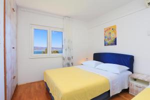 a white bedroom with a bed and a window at Apartments by the sea Balica Rat, Omis - 2753 in Tice