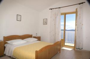 1 dormitorio con 1 cama y balcón con vistas. en Apartments by the sea Pisak, Omis - 2750, en Pisak