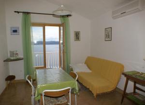 Habitación con sofá, mesa y ventana en Apartments by the sea Pisak, Omis - 2750, en Pisak