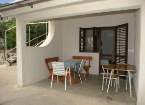 una mesa y sillas en el patio de una casa en Apartments by the sea Pisak, Omis - 2750, en Pisak