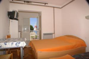 Schlafzimmer mit einem Bett, einem TV und einem Balkon in der Unterkunft Apartments by the sea Podaca, Makarska - 3037 in Podaca