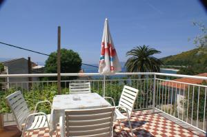 einen Tisch und Stühle auf einem Balkon mit Sonnenschirm in der Unterkunft Apartments by the sea Podaca, Makarska - 3037 in Podaca