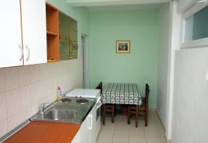 een kleine keuken met een wastafel en een tafel bij Apartments by the sea Podaca, Makarska - 2695 in Podaca +27 foto's