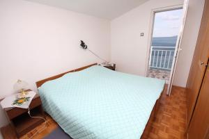 een slaapkamer met een groot bed en een balkon bij Apartments by the sea Podaca, Makarska - 2695 in Podaca