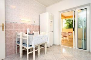 jadalnia ze stołem i lodówką w obiekcie Apartments and rooms by the sea Zivogosce - Porat, Makarska - 2733 w mieście Živogošće