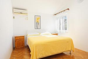 a bedroom with a bed with a yellow blanket at Apartment Duce 2737b in Duće