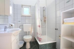 La salle de bains blanche est pourvue de toilettes et d'un lavabo. dans l'établissement Apartment Duce 2737b, à Duće