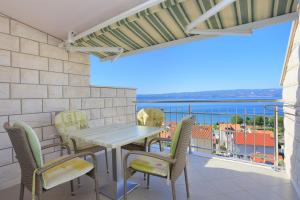 a balcony with a table and chairs and a view of the ocean at Apartment Duce 2737b in Duće