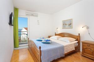 una camera con un letto e una grande finestra di Apartments by the sea Duce, Omis - 2737 a Duće