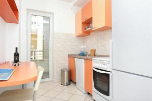 a kitchen with orange cabinets and a table and a stove at Apartment Stanici 2764a in Tice +21 photos