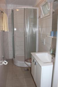 a bathroom with a shower and a toilet and a sink at Apartments by the sea Mimice, Omis - 2774 in Mimice