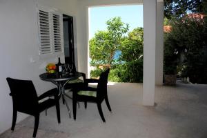 a patio with a table and chairs and a window at Apartments by the sea Mimice, Omis - 2774 in Mimice