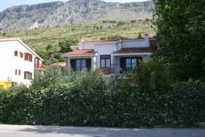 a white house with a mountain in the background at Studio Duce 2746b in Duće