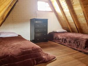 a bedroom with two beds and a dresser in a attic at Finca Masada in Mira