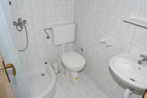 a white bathroom with a toilet and a sink at Studio Duce 2746b in Duće