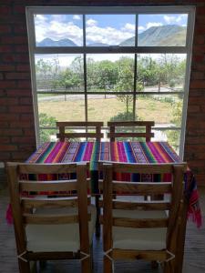 a table with two chairs and a colorful quilt on it at Finca Masada in Mira