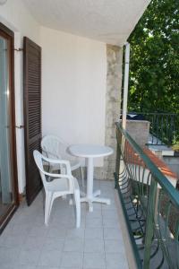 a white table and chairs on a balcony at Apartments and rooms by the sea Duce, Omis - 2746 in Duće
