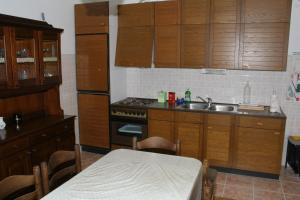 a kitchen with wooden cabinets and a table and a sink at Apartments and rooms by the sea Duce, Omis - 2746 in Duće