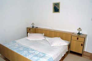 um quarto com uma cama e uma fotografia na parede em Apartments with a parking space Omis - 2751 em Omiš