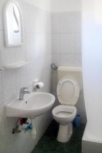 a white bathroom with a toilet and a sink at Apartment Drvenik Donja vala 2732a in Drvenik