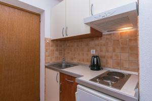 uma pequena cozinha com um fogão e um lavatório em Studio Brela 2752d em Brela