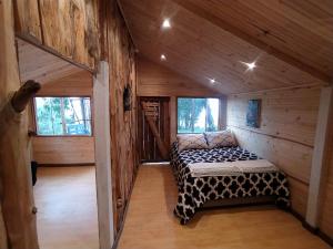 a room with a bed in a wooden cabin at La chala Guatavita in Guatavita