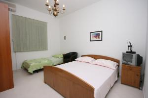 een slaapkamer met een bed en een tv. bij Apartments with a parking space Duce, Omis - 2801 in Omiš