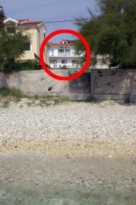 een rood bord voor een huis bij Apartments by the sea Orij, Omis - 2810 in Dugi Rat