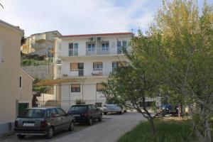 twee auto's geparkeerd voor een gebouw bij Apartments by the sea Orij, Omis - 2810 in Dugi Rat