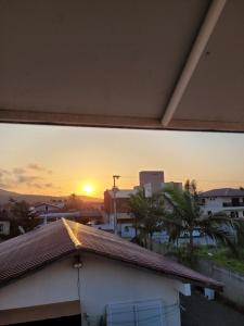 una puesta de sol vista a través de una ventana de un edificio en Apartameto 2 quartos perto da praia e Beto Carrero, en Penha