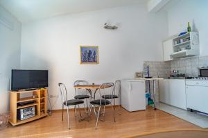 a kitchen with a table and chairs and a television at Apartment Sumpetar 2808b in Sumpetar